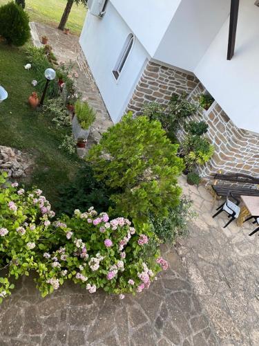 a garden with flowers and a bench on a patio at Guest House Debar in Arbanasi