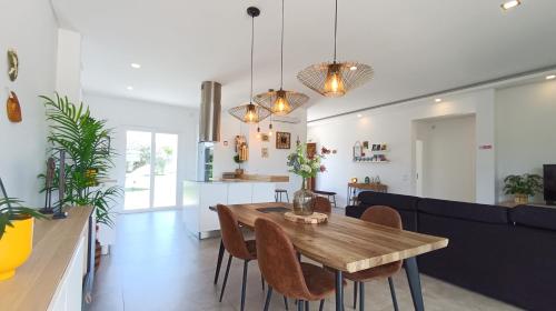 a dining room and living room with a wooden table and chairs at Sunset River Villa, Lisbon in Alcochete
