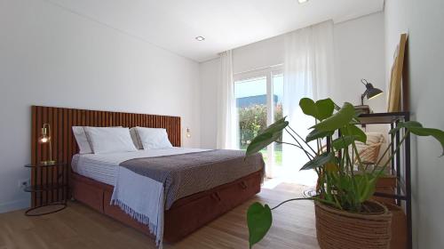 a bedroom with a bed and a large window at Sunset River Villa, Lisbon in Alcochete