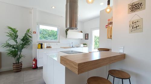 a kitchen with white walls and a wooden counter top at Sunset River Villa, Lisbon in Alcochete