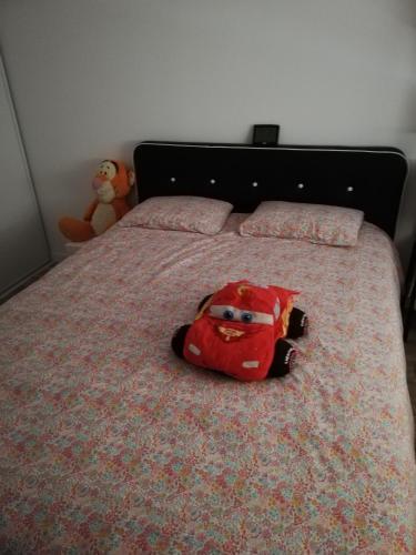 une petite voiture est assise sur un lit dans l'établissement Maison neuve au cœur du Golf du Morbihan, à Plougoumelen