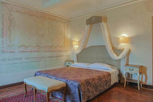 a bedroom with a bed and two stools in it at Hotel Villa Sermolli in Borgo a Buggiano