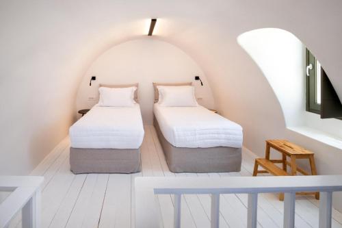 two beds in a room with an attic at Hygge Villa Santorini in Pirgos