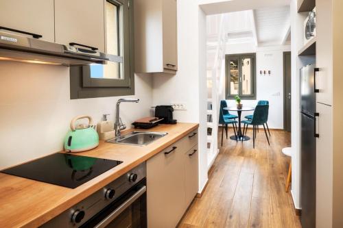 a kitchen with a sink and a table with chairs at Hygge Villa Santorini in Pirgos