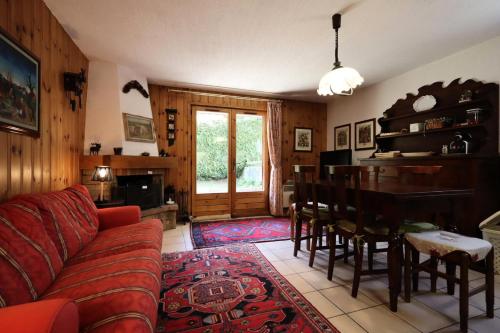 un salon avec un canapé rouge et une table dans l'établissement Résidence Les Eaux Rousses - Les Eaux Rousses MAE-9964, aux Houches