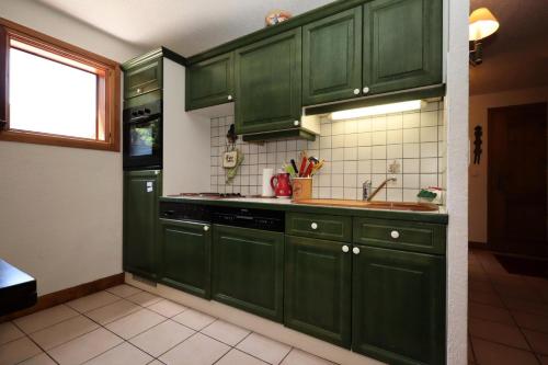 - une cuisine verte avec des placards verts et un évier dans l'établissement Résidence Les Eaux Rousses - Les Eaux Rousses MAE-9964, aux Houches