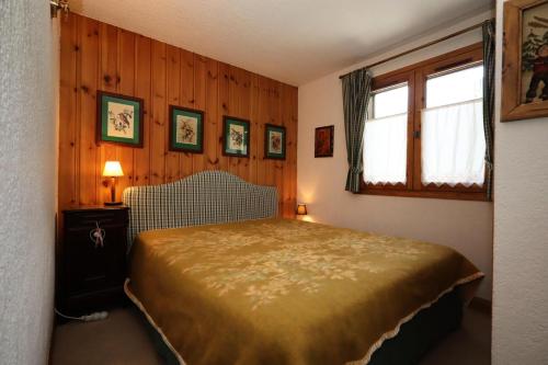 une chambre avec un lit dans une pièce aux murs en bois dans l'établissement Résidence Les Eaux Rousses - Les Eaux Rousses MAE-9964, aux Houches