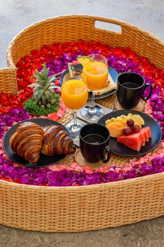 een ontbijttafel met een dienblad met eten en sinaasappelsap bij Secluded 1BR Pool Villa with Ricefield View in Berawa, 5mins Ride to Beach in Canggu