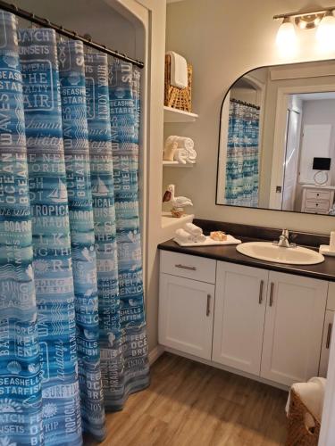 a bathroom with a shower curtain and a sink at Ocean Breeze in Ingonish Beach