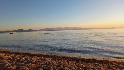 a beach with a boat in the water at Margianou Seaview Apartments 3 & 4 in Kálamos