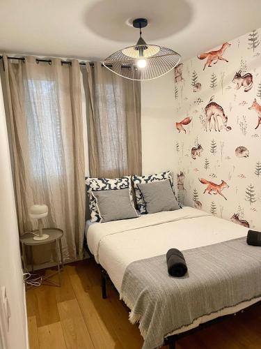 une chambre avec un lit et un mur avec des dinosaures dans l'établissement Appartement Élégant & Chic à Paris, à Paris