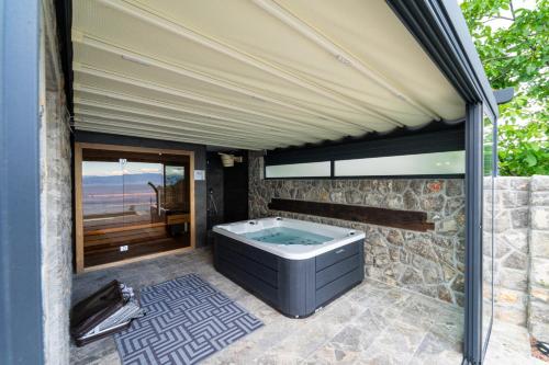 a jacuzzi tub on a patio with a window at Vila Marigold in Opatija