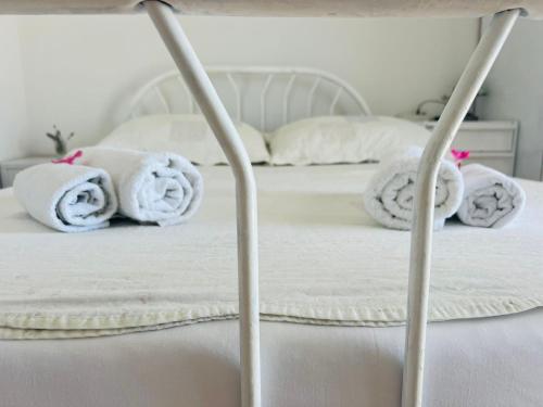 a bed with white blankets and towels on it at Apartment BIM in Pisak