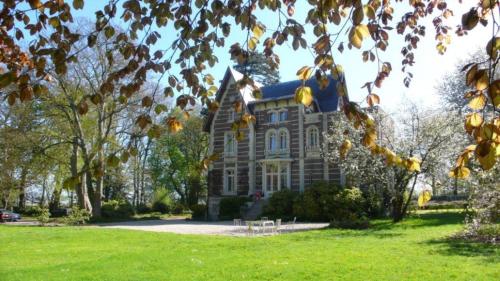 a large house on a green field with trees at Chalet Du Bel Event in La Chapelle-sur-Dun