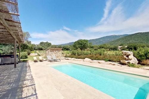 a swimming pool with a view of a mountain at ARGIALE - ARGHJALE in Figari