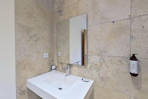 a bathroom with a white sink and a mirror at ARGIALE - ARGHJALE in Figari