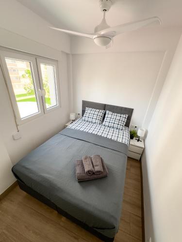 a bedroom with a large bed with two windows at SoleOle in Playa de Gandia