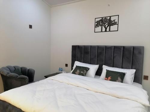 a bedroom with a large bed with a black headboard at Cherry Garden Terrace Hotel & Restaurant in Gilgit