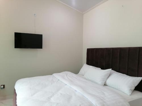 a bedroom with a bed with a television on the wall at Cherry Garden Terrace Hotel & Restaurant in Gilgit