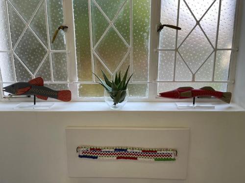 a window in a bathroom with a vase on a shelf at Home of Synergy in Johannesburg