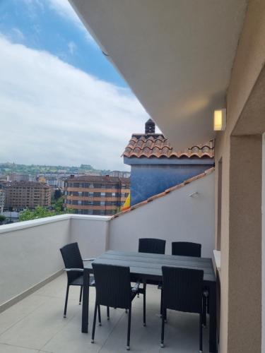 a table and chairs on a balcony with a view at ASTURES Viviendas Turísticas in Oviedo