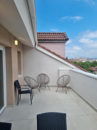 a balcony with three chairs and a table and chairs at ASTURES Viviendas Turísticas in Oviedo