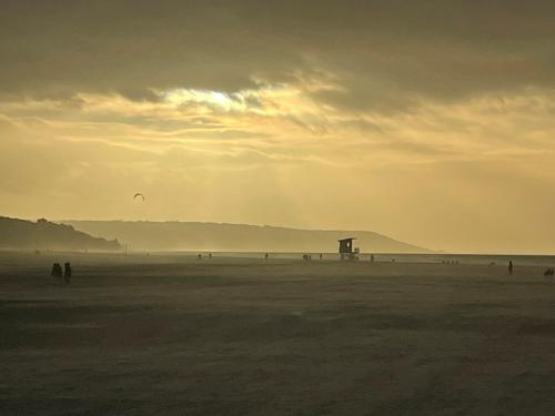 a group of people walking on the beach at Best view sea Deauville in Deauville