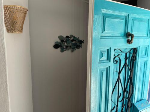a blue door with a black design on a wall at Casa Ariana, casco antiguo, terrazas con vistas al mar in Altea