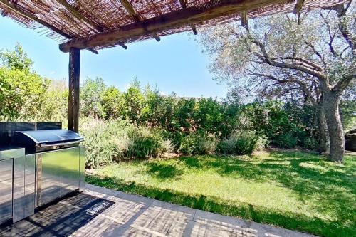 an outdoor kitchen with a view of a yard at ARGIALE - ARGHJALE in Figari