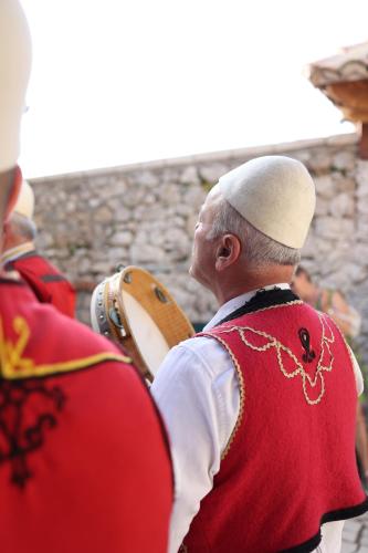 a man in a red uniform standing next to a man holding a drum at Kruja Albergo Diffuso , Inside Kruja Castle in Krujë
