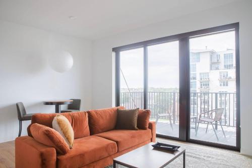 a living room with a couch and a balcony at Chic East Side 1BR Apt with Balcony, Pool, and Gym in Milwaukee