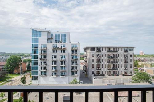 a view of two buildings from a balcony at Chic East Side 1BR Apt with Balcony, Pool, and Gym in Milwaukee