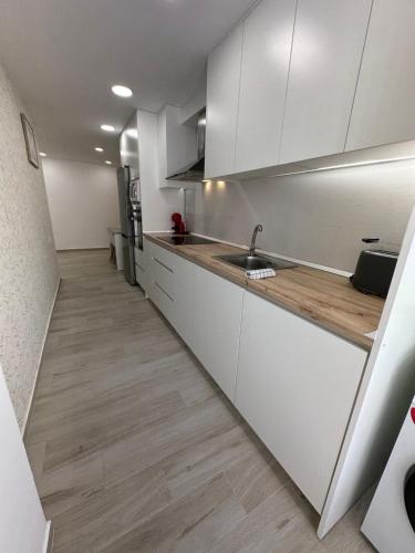 a kitchen with white cabinets and a sink at El Mirador De Casablanca in Alcantarilla