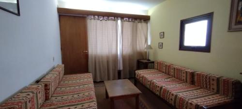 a waiting room with three couches and a window at Aconcagua Departamento in Los Penitentes