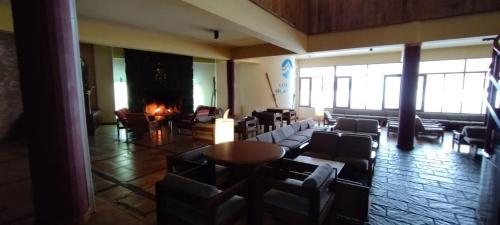a lobby with couches and chairs and a fireplace at Aconcagua Departamento in Los Penitentes