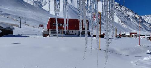 a red train on a snow covered mountain at Aconcagua Departamento in Los Penitentes