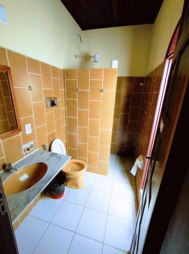 a bathroom with a sink and a toilet at Pousada Verdes Mares in Alcobaça