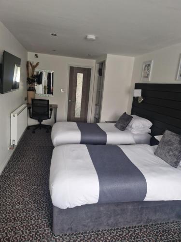 a hotel room with three beds and a desk at Posyrooms in Manchester