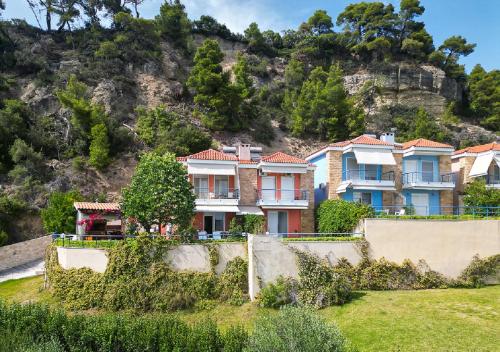 a row of houses in front of a mountain at Hermes villa Possidi in Possidi