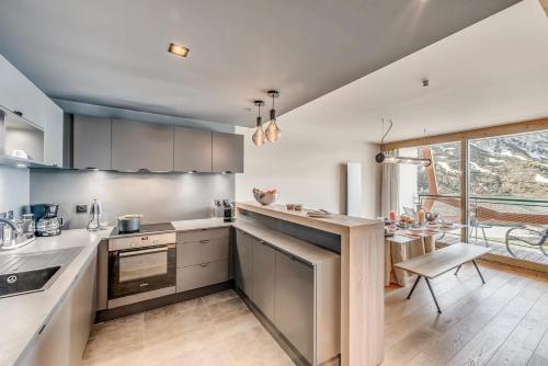 d'une cuisine équipée d'appareils en acier inoxydable et d'une grande fenêtre. dans l'établissement Résidence Phoenix - 4 pièces 6 personnes 4 MAE-7211, à Tignes