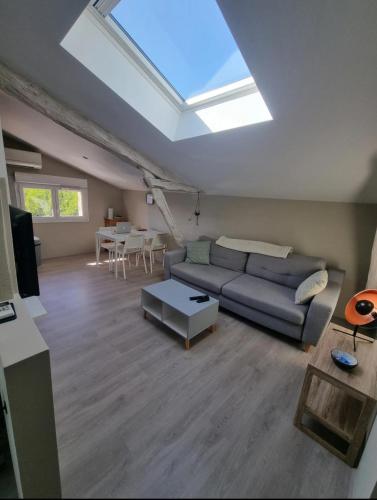 - un salon avec un canapé et une lucarne dans l'établissement Joli petit logement avec fraîcheur et confort, à Lescure-dʼAlbigeois