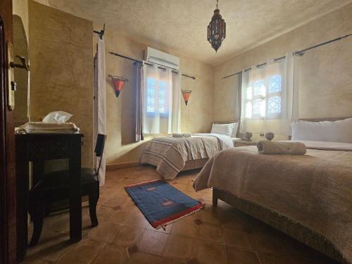 a bedroom with two beds and a piano at Kasbah La Cigogne in Aït Ben Haddou