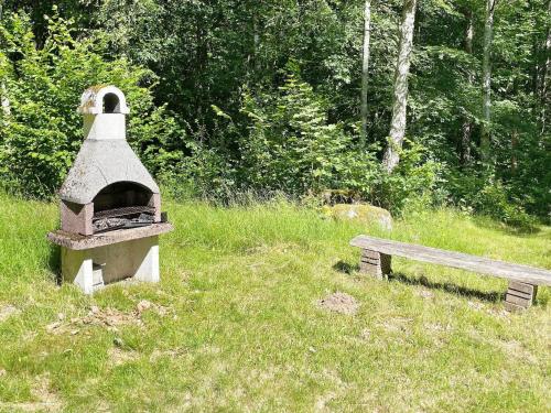 a bird house and a bench in a field at 4 star holiday home in Backaryd in Backaryd