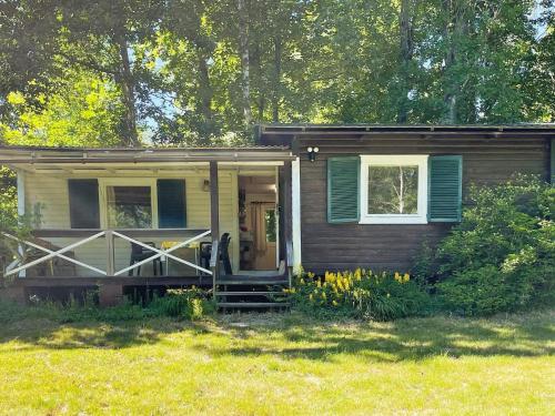 a small house with the door open in a field at 4 star holiday home in Backaryd in Backaryd