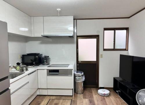 a kitchen with white cabinets and a stove top oven at 嵐天RanTen in Shimo saga