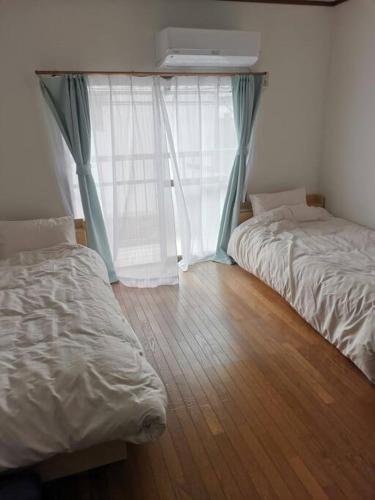 a bedroom with two beds and a window at 嵐天RanTen in Shimo saga