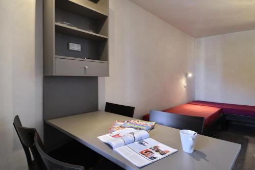 Cette petite chambre comprend une table et un lit. dans l'établissement Residence 3000 - Studio pour 4 Personnes 31, à Mâcot La Plagne