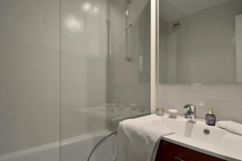 une salle de bain blanche avec un lavabo et une douche dans l'établissement Residence 3000 - Studio pour 4 Personnes 31, à Mâcot La Plagne