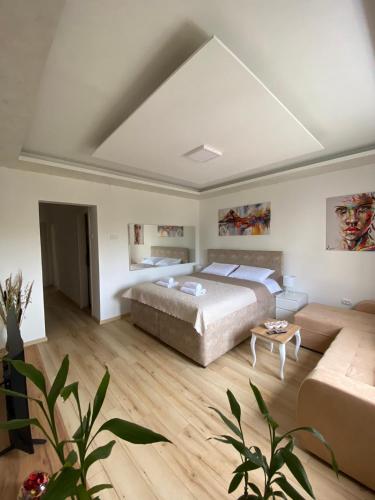a large bedroom with a bed and a couch at Comfort studio Lepa Kata in Podgorica