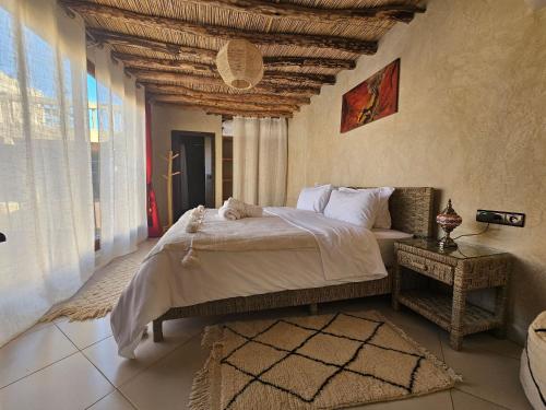 a bedroom with a large bed and a large window at Kasbah La Cigogne in Aït Ben Haddou